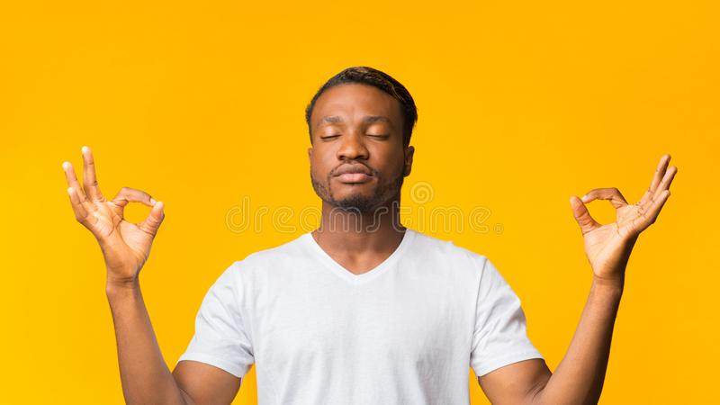 black man meditating standing over yellow background panorama zen relaxed black man meditating standing over yellow background 160931725